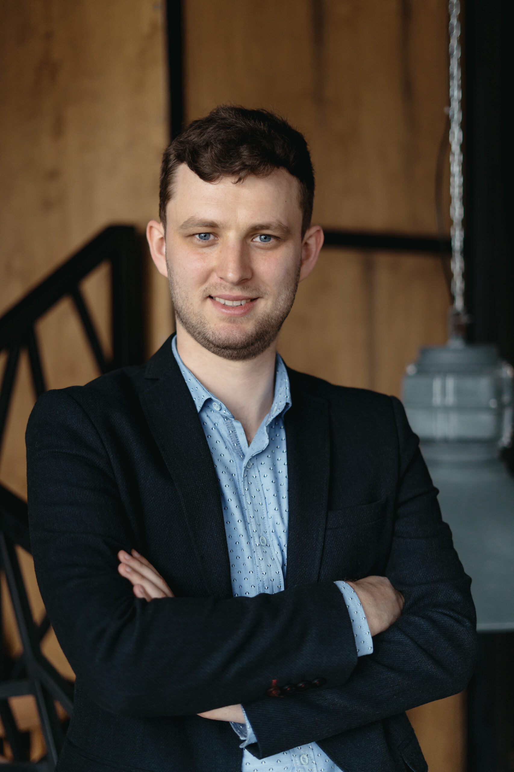 Executive manager portrait looking at camera standing in modern loft space.